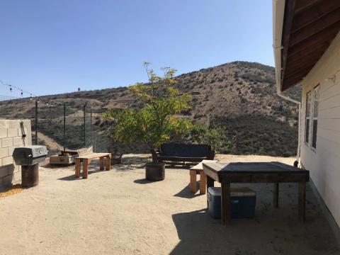 patio trasero con asador fogatero bancas y mesa